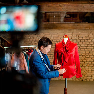 Einblick in eine Kursaufnahme im Atelier: Arbeit an einer roten Bluse an einer Schneiderpuppe.
